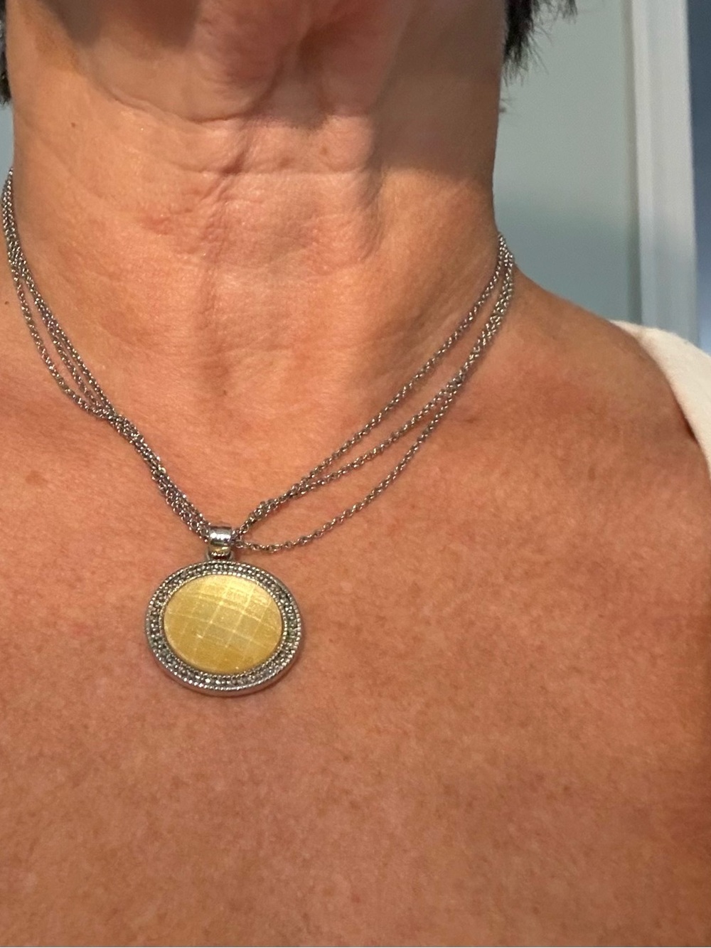 Mother of pearl colored pendant on silver tone chain